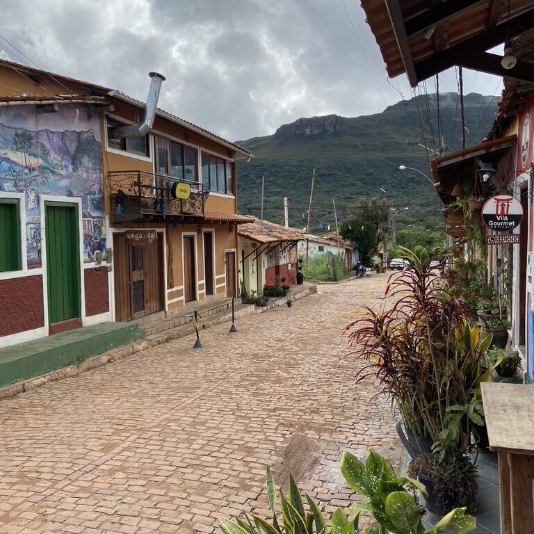 rue pavée avec maisons colorées et montagne à Capao